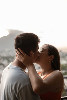 A couple shares a tender kiss during a sunset in Monterrey, Mexico, symbolizing love and intimacy.