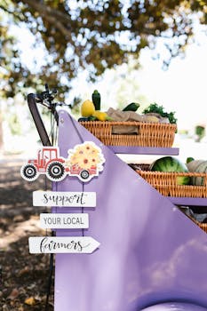 Colorful display promoting local farmers with fresh produce and signage outdoors.