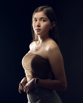 Portrait of a stylish young woman in elegant attire, captured in studio lighting.