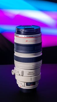 Studio photo of a telephoto camera lens against a bright, abstract background.